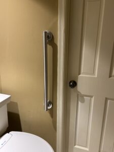 Vertical grab bar next to the water closet